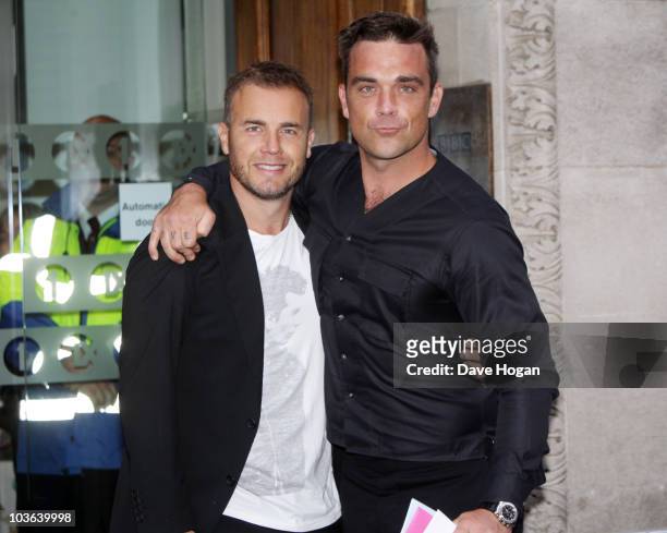 Gary Barlow and Robbie Williams pose before being interviewed by Chris Moyles on Radio 1 at The Radio 1 Building on August 26, 2010 in London,...
