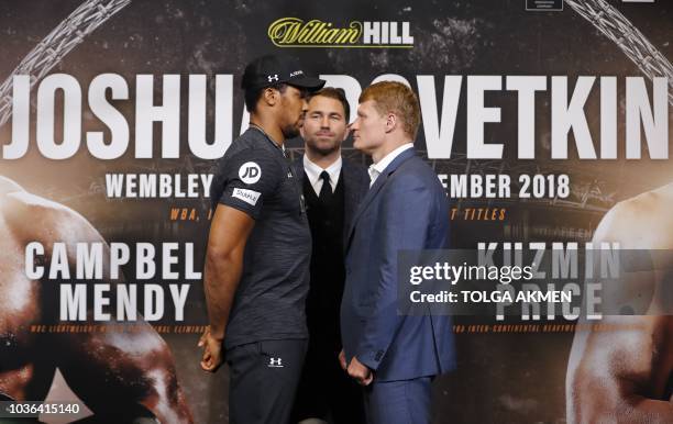 Britain's Anthony Joshua poses by his challenger Russia's Alexander Povetkin during a joint press conference at Wembley stadium in London on...