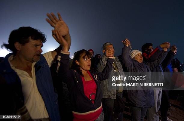 Relatives of the miners trapped in the San Esteban gold and copper mine, hug each other as the news after the confirmation of the survival of the 33...