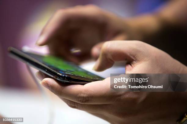 Booth attendant plays a video game on a smartphone during the Tokyo Game Show 2018 on September 20, 2018 in Chiba, Japan. The Tokyo Game Show is held...