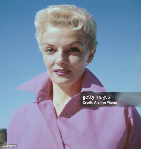 Headshot of actress Jane Russell pictured wearing a wide-collared pink shirt, USA, circa 1960. A blonde Russell is also wearing lipstick which...