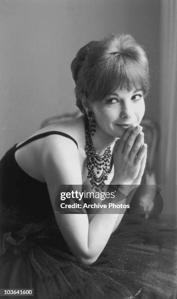 Actress Romy Schneider pictured leaning forward on her elbows with both hands supporting her chin, USA, circa 1965.