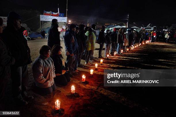 Relatives of trapped miners pray and light candles outside the San Esteban gold and copper mine, near the city of Copiapo, in the arid Atacama...
