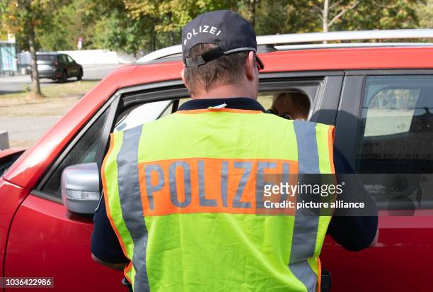 September 2018, Berlin: A police officer talks to a driver about using a mobile phone in the car. The Berlin police participated in the nationwide...