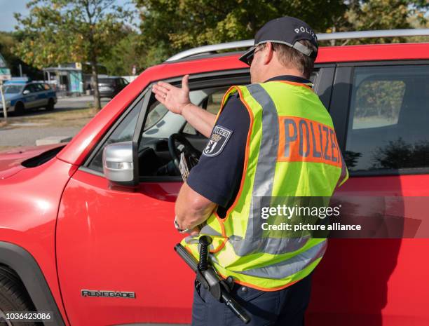 September 2018, Berlin: A police officer talks to a driver about using a mobile phone in the car. The Berlin police participated in the nationwide...