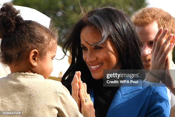 Meghan, Duchess of Sussex interacts with a young girl at an event to mark the launch of a cookbook with recipes from a group of women affected by the...