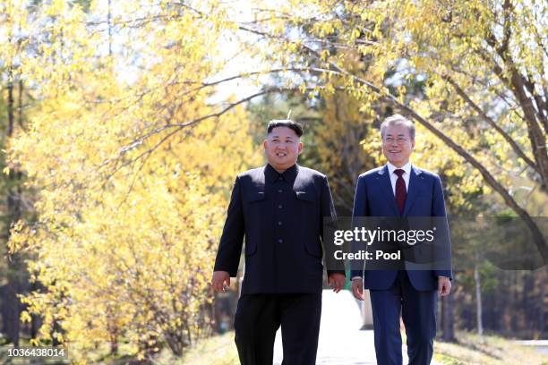 North Korea's leader Kim Jong Un and South Korean President Moon Jae-in walk together during a visit to Samjiyon guesthouse on September 20, 2018 in...
