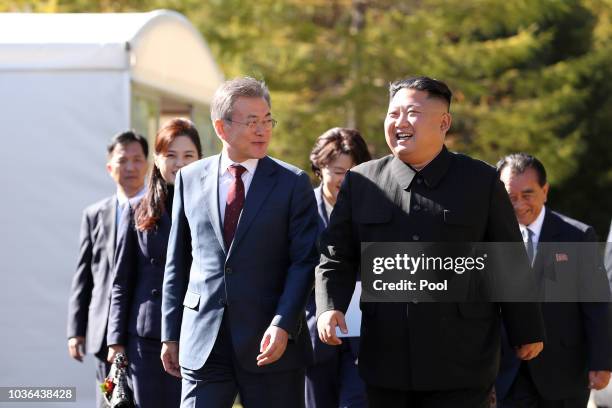 North Korea's leader Kim Jong Un walk with South Korean President Moon Jae-in during a visit to Samjiyon guesthouse in Samjiyon on September 20, 2018...