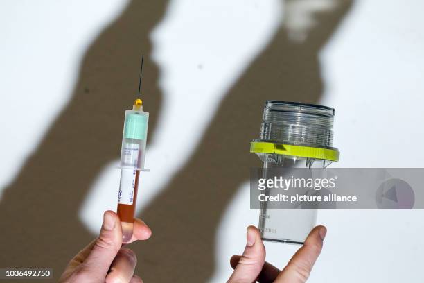 Syringe and a container for test tubes are presented during the demonstration of a doping test for horses in a stable in Riesenbeck, Germany, 09...