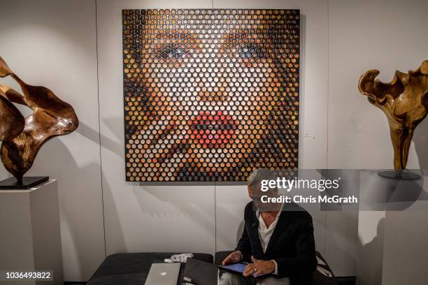 Man sits in front of artwork on display at Contemporary Istanbul on September 20, 2018 in Istanbul, Turkey. The 13th edition of Contemporary Istanbul...