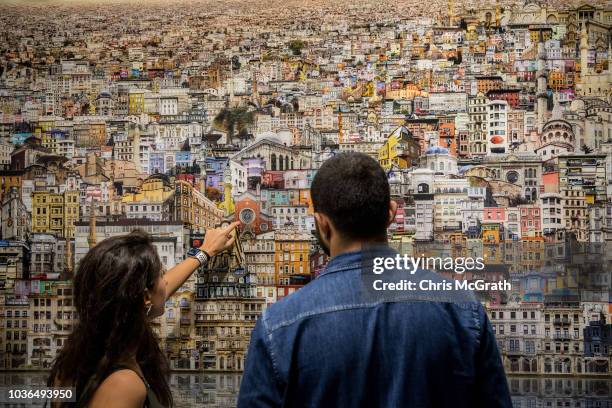 People view an artwork by Jean-Francois Rauzier on display at Contemporary Istanbul on September 20, 2018 in Istanbul, Turkey. The 13th edition of...