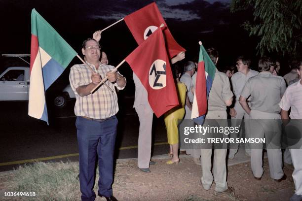 Men wave the far-right movement AWB flag during the vote of parents of a school, concerning the participation of a black athlete in a sport...