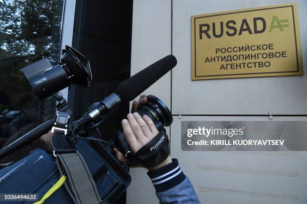 Journalist films the sign on the RUSADA building in Moscow on September 20, 2018. - The World Anti-Doping Agency on September 20, 2018 lifted a ban...