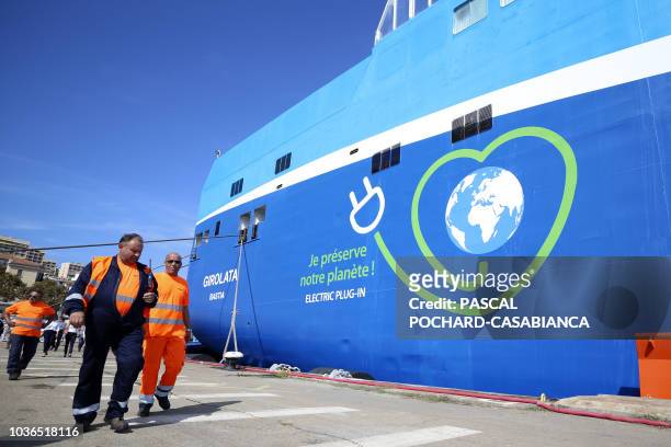 Workers walk past the "Girolata" ferry of La Meridonale company on September 20 in Ajaccio, on the French Mediterranean Island of Corsica. - La...