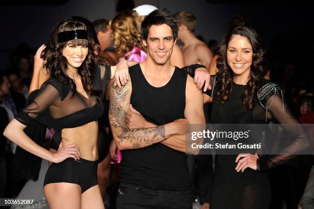 Model poses with Mitchell Johnson and Giaan Rooney on the catwalk during the Hot In The City Intimates group show as part of Rosemount Sydney Fashion...