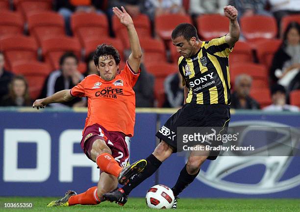 Thomas Broich of the Roar tackles Emmanuel Muscat of the Phoenix during the round four A-League match between the Brisbane Roar and the Wellington...