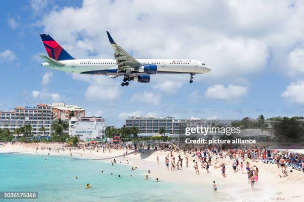 An airplane flying just above beachgoers in Maho Beach as it approaches the landing strip in Sint Maarten, 30 March 2016. Photo: Philipp...