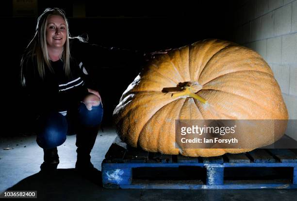 Laura Litchfield from Mansfield poses next to her giant pumpkin after arriving through the night as she prepares for the giant vegetable competition...