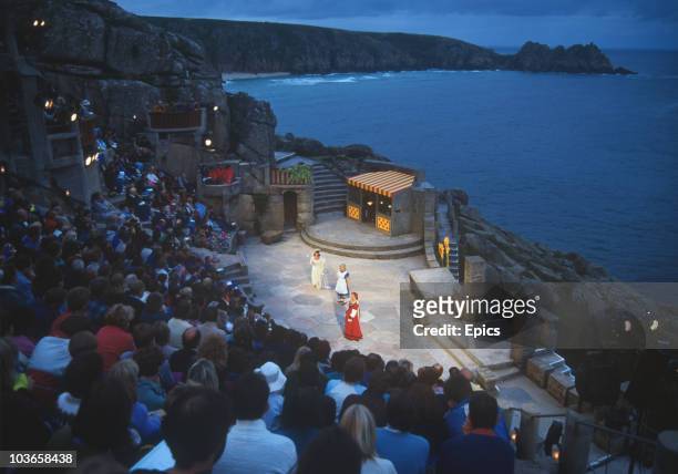 An audience watch a performance at the open air Minack Theatre on the coast of Porthcurno, Penzance, Cornwall, circa 1984.