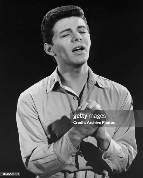 Singer and actor Frankie Avalon pictured, with his hands clasped together and eyes closed while singing, USA, circa 1960.