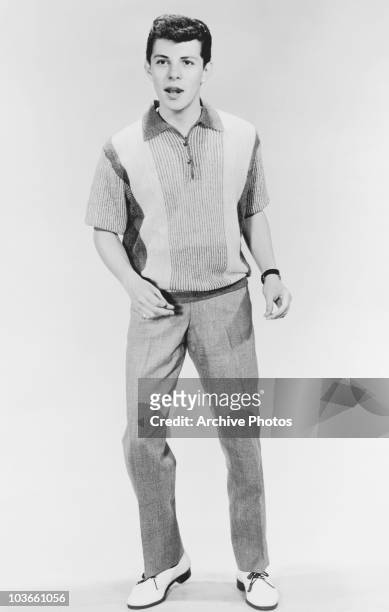 Full-length shot of singer and actor Frankie Avalon holding a pose in a studio portrait, USA, circa 1955.