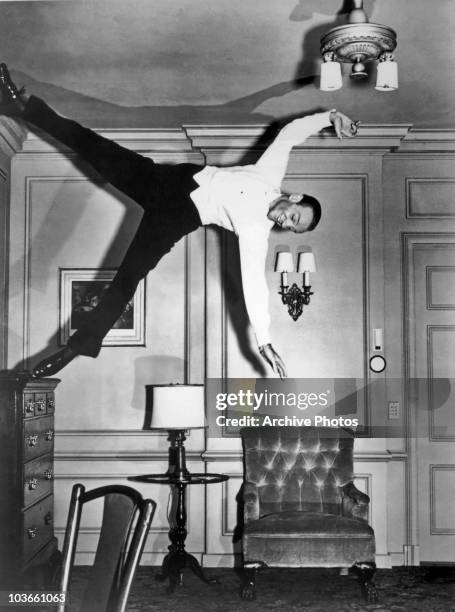 Actor and dancer Fred Astaire pictured during a scene from the film, 'Royal Wedding', USA, circa 1951. The dramatic scene appears to show Astaire...