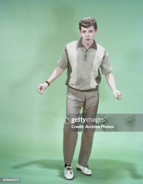 Full-length shot of singer and actor Frankie Avalon holding a pose in a studio portrait, USA, circa 1955.