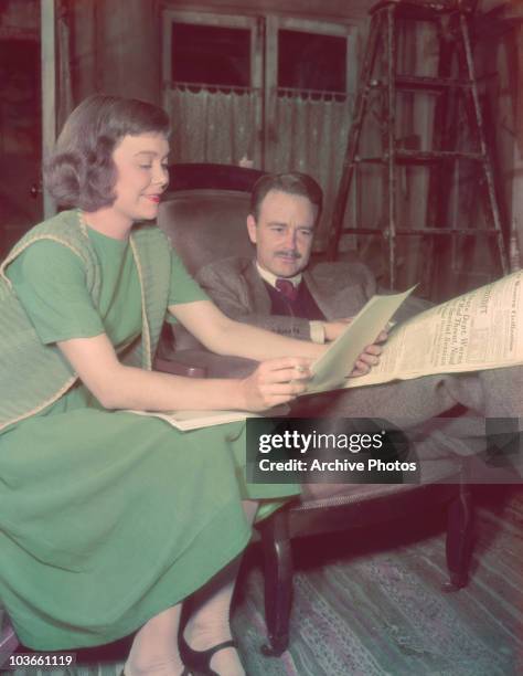 Actress Jane Wyman reading a script alongside actor Lew Ayres , who is reading a newspaper, on the set of a film, USA, circa 1948. Wyman and Ayres...
