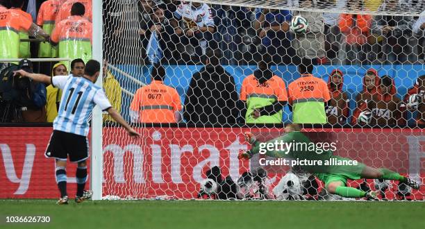 Argentina's Maxi Rodriguez scores the 2-4 goal during the penalty shoot-out against goalkeeper Jasper Cillessen of the Netherlands during the FIFA...