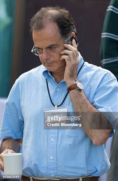 Andras Simor, governor of the National Bank of Hungary, talks on his mobile phone during a break of the Federal Reserve Bank of Kansas City annual...