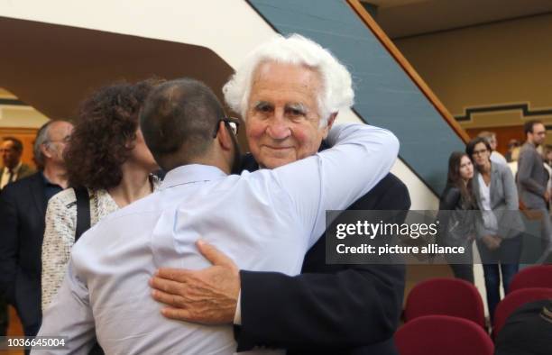 Auschwitz survivor William Glied being hugged by his grandson at the regional court in Detmold, Germany, 17 June 2016. The court sentenced the former...