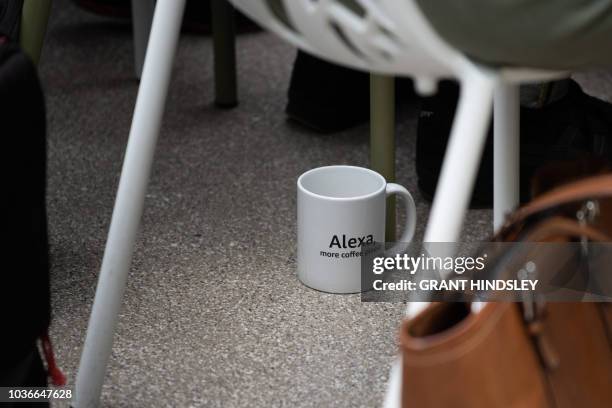 An Alexa-themed coffee mug sits under a reporter during Dave Limp, senior vice president of Amazon devices', presentation announcing new Alexa...