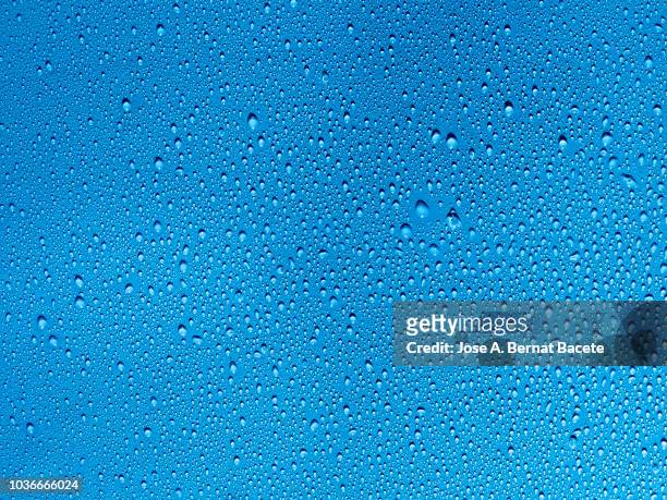full frame of the textures formed by the bubbles and drops of water, on a smooth  blue background. - dew texture stock pictures, royalty-free photos & images