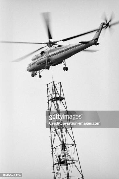 The Mil Mi-10K flying crane helicopter of Aeroflot pictured while replacing 122m-high radio tower located Shabolovka district, Moscow, USSR.