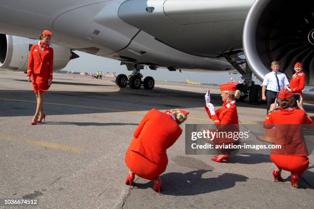 Aeroflot's flight attendants pose for photos near the Airbus A350 civil jet airplane during its visit into Sheremetyevo airport, Moscow, Russia.