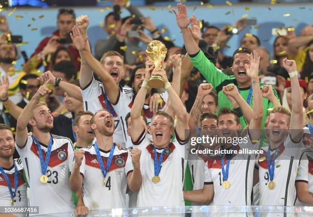 Bastian Schweinsteiger of Germany lifts up the World Cup trophy after winning the FIFA World Cup 2014 final soccer match between Germany and...