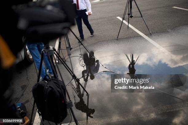 Member of the media is reflected in a puddle after a press conference regarding the shooting of multiple people on September 20, 2018 in Aberdeen,...