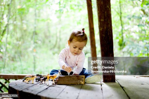 cute girl playing with toy animals - toy animal stock pictures, royalty-free photos & images