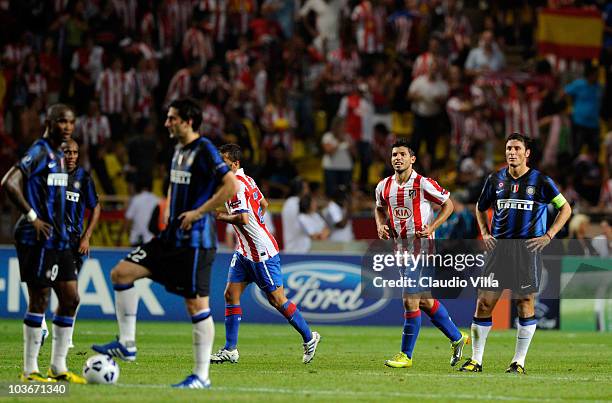 Sergio Aguero of Atletico celebrates after scoring his team's second goal as Javier Zanetti of Inter shows his dejection during the UEFA Super Cup...