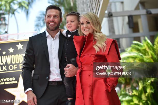 Singer Carrie Underwood poses with her husband Mike Fisher and their 3-year-old son Isaiah Michael at her star unveiling ceremony on the Hollywood...