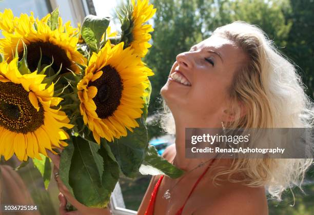 smiling woman holding a bouquet of sunflowers - lithuania woman stock pictures, royalty-free photos & images