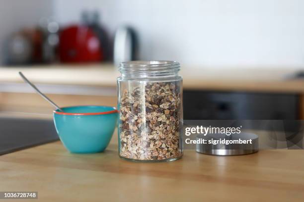 jar of muesli and a  bowl on a kitchen table - jars kitchen stock pictures, royalty-free photos & images