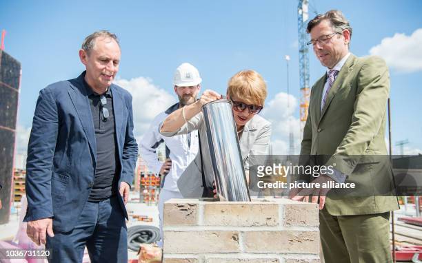 Brandenburg State Minister of Science Martina Muench places the time capsule in the foundation stone at the groundbreaking for the new Central Art...