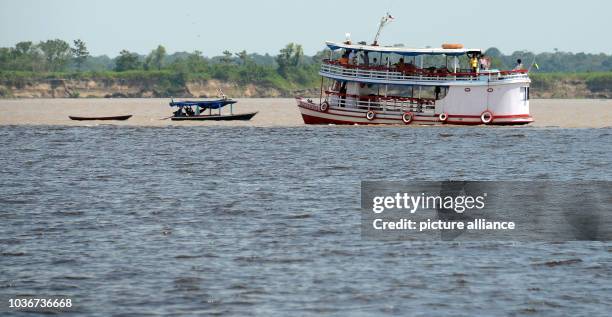 Boats are pictured at the confluence of the Solimões, the upper stretch of the Amazon River, and the Rio Negro near Manaus, Brazil, 11 December 2013....
