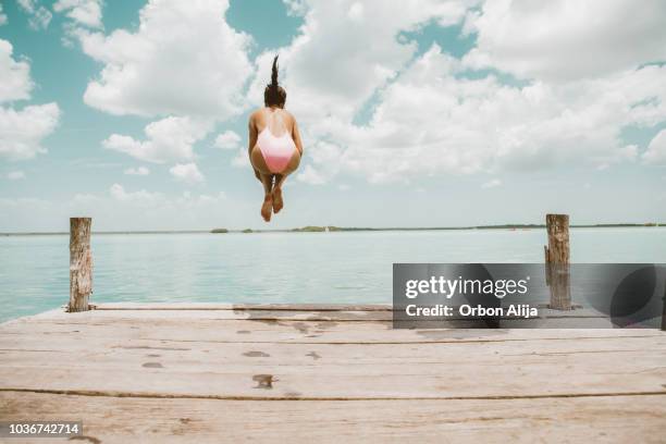 桟橋から飛び降りて女性 - floating piers ストックフォトと画像