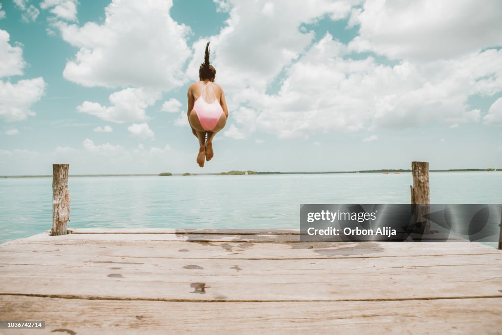 Woman jumping from pier