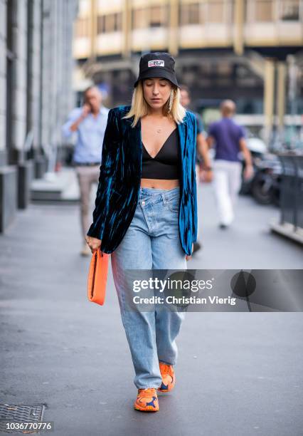 Sonia Lyson wearing orange Adidas sneaker, fisher hat Prada, asymmetric jeans Agolde bustier Zara, velvet blazer YSL, orange clutch Prada is seen...