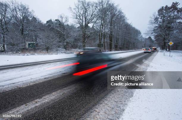 Cars drive along a partly icey road close to Schwerin, Germany, 29 December 2014. Black ice and a thin layer of snow have complicated the start of...