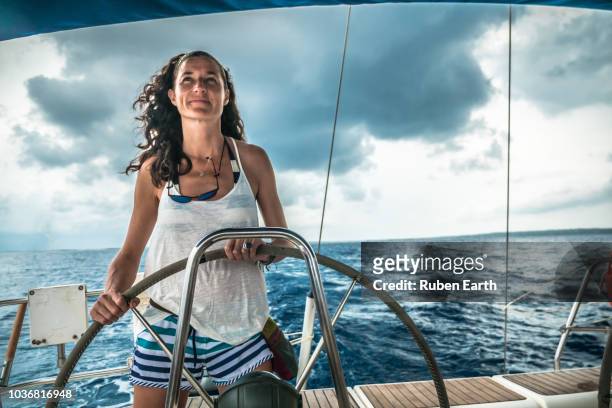 woman piloting a sailboat - team captain stock pictures, royalty-free photos & images