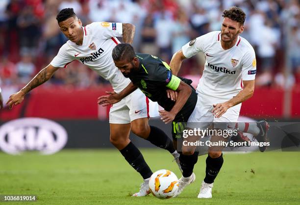 Guilherme Arana and Sergi Gomez of Sevilla compete for the ball with Mehdi Carcela-Gonzalez of Royal Standard de Liege during the UEFA Europa League...